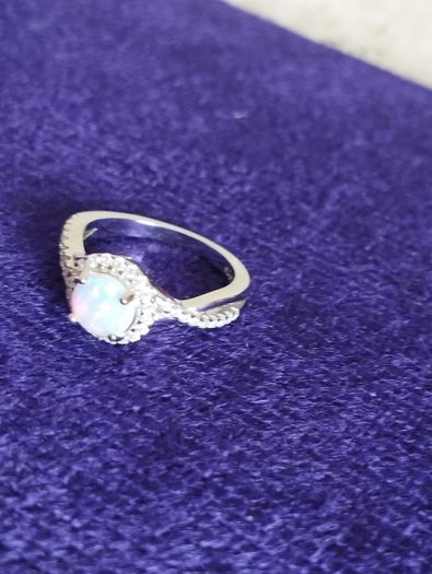 A beautiful 925 silver ring with a white lab opal surrounded by shining cubic zirconia.