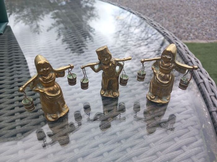 3 brass figures with water buckets, D18 post 7e