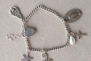 Vintage sterling silver bracelet with charms. Please note that only one charm is not sterling silver. It is a small size, approximately 16/17 cm.