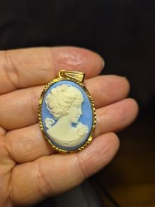 Vintage Cameo Goldtone Pendant on a Blue Background