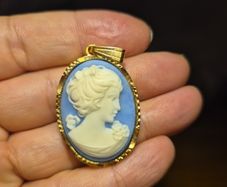Vintage Cameo Goldtone Pendant on a Blue Background