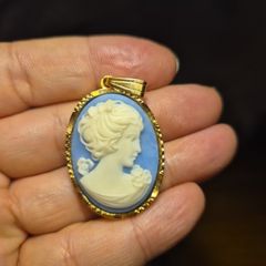 Vintage Cameo Goldtone Pendant on a Blue Background