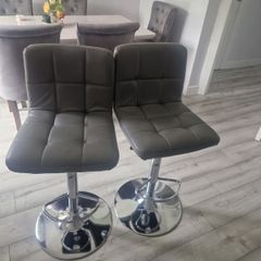 2 grey leather look swivel bar stools