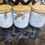 white ceramic tea, coffee, and sugar storage canisters accented with embossed daisy patterns and rustic twine bows. Image 3