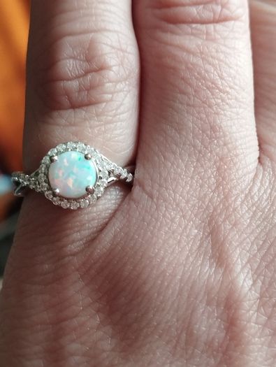 A beautiful 925 silver ring with a white lab opal surrounded by shining cubic zirconia.