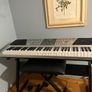 RockJam Electronic Keyboard Piano set up on a sturdy, matching heavy-duty Z-frame stand and an adjustable padded X-frame RockJam Keyboard Bench resting on a wooden surface. Image 6