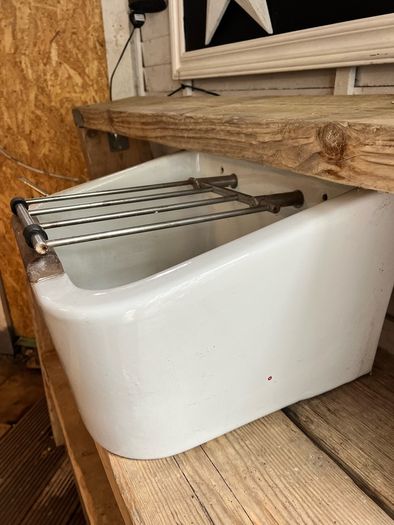Heavy vintage ceramic basin with a built-in metal rack.
