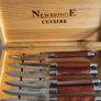 A Newbridge Cuisine set of six steak knives with serrated blades and wooden handles. Image 6