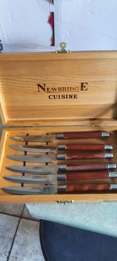 A Newbridge Cuisine set of six steak knives with serrated blades and wooden handles.
