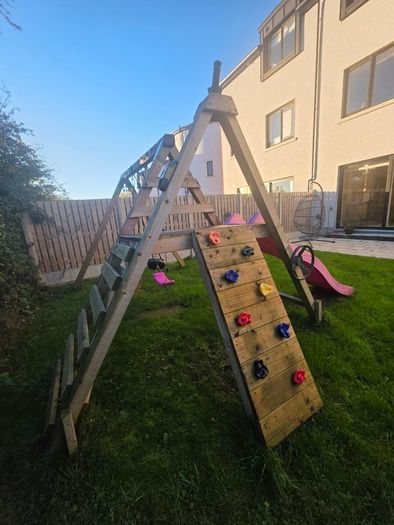 Wooden climbing frame with slide and swings