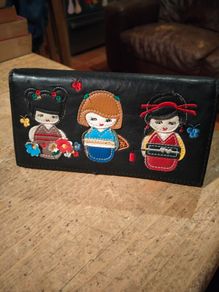 black faux leather wallet,featuring three embroidered Japanese Kokeshi doll