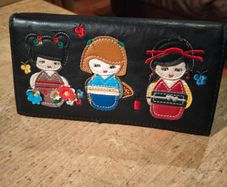 black faux leather wallet,featuring three embroidered Japanese Kokeshi doll
