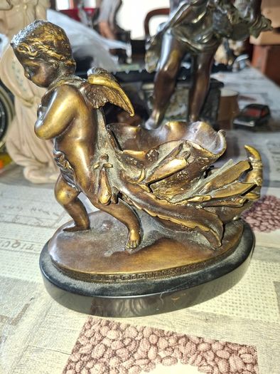 Antique French 19th century Bronze Sculpture Auguste Moreau featuring a Winged Putto Cherub Cupid carrying a shell or cornucopia like vessel, mounted on a marble base