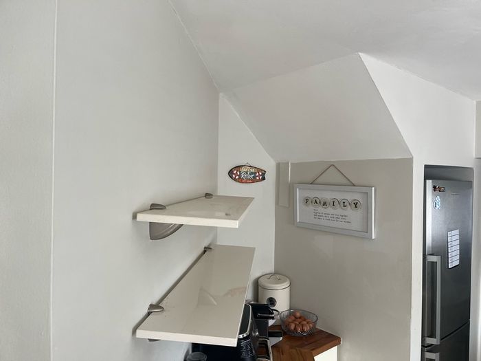 A pair of e floating wall shelves mounted on decorative metal shelf brackets.