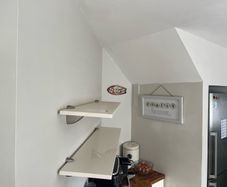 A pair of e floating wall shelves mounted on decorative metal shelf brackets.