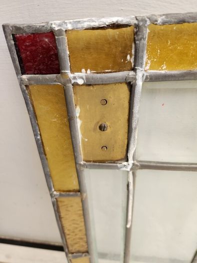 Vintage leaded glass with curved brass screen .