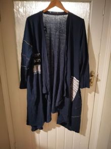long-sleeved navy garment is an oversized graphic Jacket cardigan.