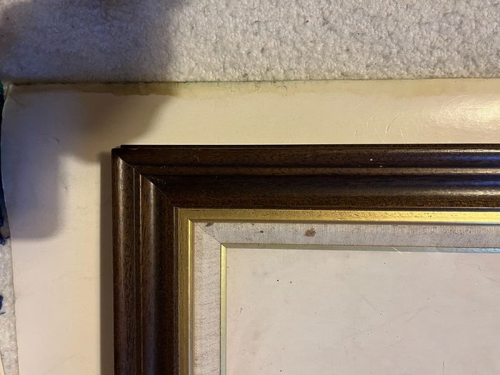 frame A rich dark-wood and gilt picture frame featuring a textured fabric mat liner.