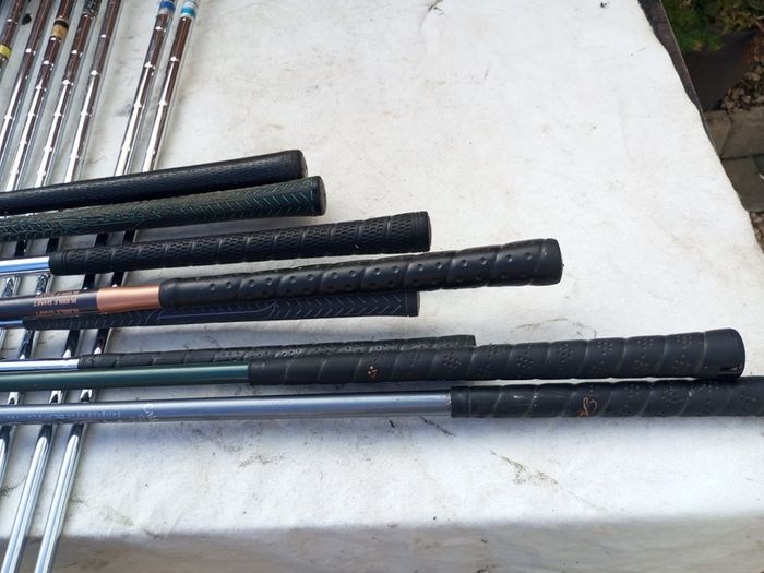 A selection of golf clubs and bags. All right handed clubs.