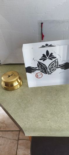 2 Papper Weight , Brass Papper Weight marked ISLAND 12.00 euro. Cleare Risen Tile Papper Weight.with black velvet on the back.10.00 euro.