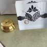 2 Papper Weight , Brass Papper Weight marked ISLAND 12.00 euro. Cleare Risen Tile Papper Weight.with black velvet on the back.10.00 euro. Image 2