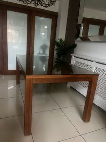Brown wooden dining table with glass top