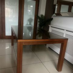 Brown wooden dining table with glass top