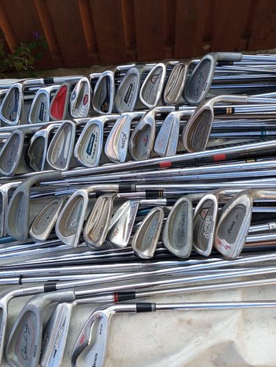 A selection of golf clubs and bags. All right handed clubs.