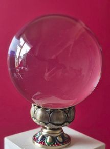 Crystal glass ball on metal lotus flower base.