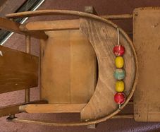 Vintage wooden doll high chair FROM THE 1930S featuring a built-in play tray with a wire bead