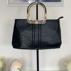 Black handbag featuring gold handles