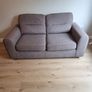 Grey two-seater sofa bed with matching storage footstool Image 2