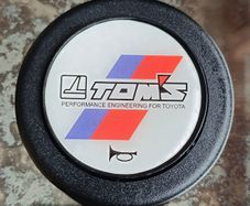 Genuine vintage TOM'S horn button for Toyota steering components.