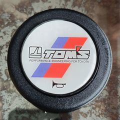 Genuine vintage TOM'S horn button for Toyota steering components.