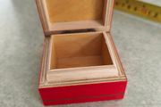 A small wooden trinket / gift box painted red with hand painted flower.