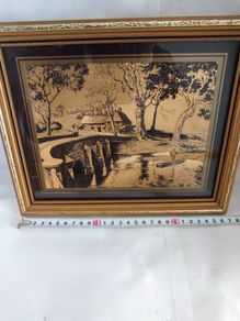 Lovely gold picture of bridge and boy in boat.