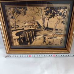 Lovely gold picture of bridge and boy in boat.