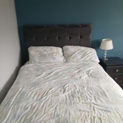 Double bed with grey upholstered headboard and storage drawer