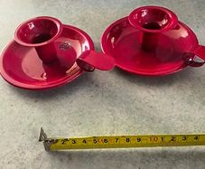 Set of 2  Red enamel candlestick holder and drip tray featuring a Considered by Helen James 12.00 euro each.