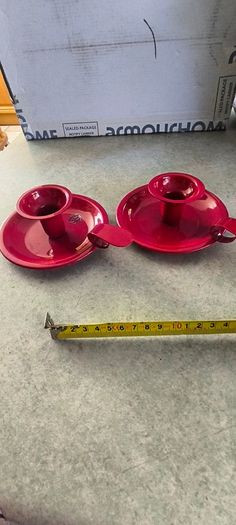 Set of 2  Red enamel candlestick holder and drip tray featuring a Considered by Helen James 12.00 euro each.