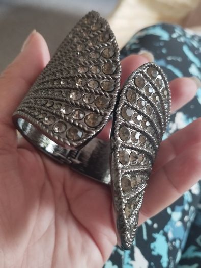 A striking wide bracelet encrusted with sparkling rhinestones.