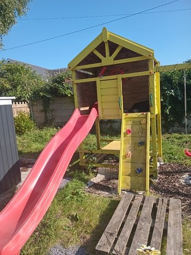 Playhouse with swings, slide, look out tower, picnic table and basketball hoop