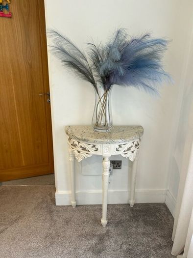 ornate half-moon console table with a granite top