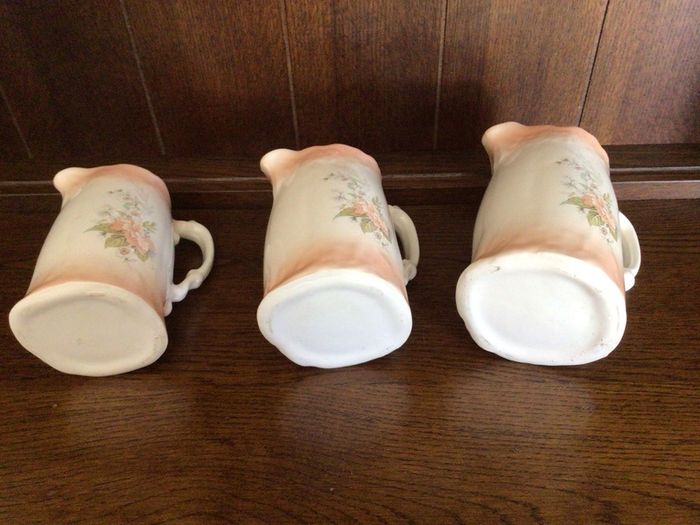 A set of 3 Large Peach Floral porcelain Graduating jugs