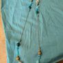 long, colorful beaded necklace featuring a mix of wood, blue, and white floral beads. Image 3