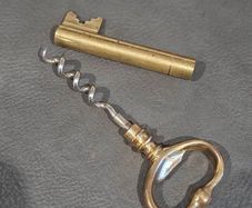 Vintage brass cloured key-shaped corkscrew and bottle opener