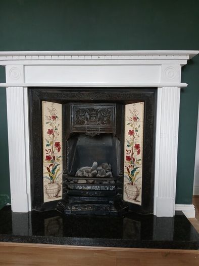 Fireplace in cast iron with wooden surround (painted white) and black marble hearth.   Perfect condition
