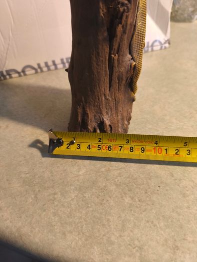 handmade iguana on natural wood log