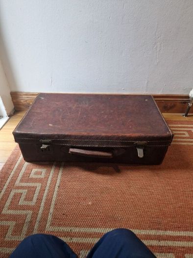 1leather suitcase and 1 faux leather suitcase.