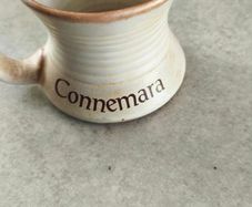 Connemara Pottery Irish stoneware mug with a cream glaze and brown rim